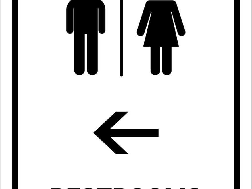 Restrooms With Left Arrow White Portrait Wall Sign